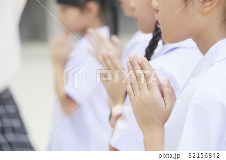 A group of schoolchildren is greeting with Thai style. 32156842