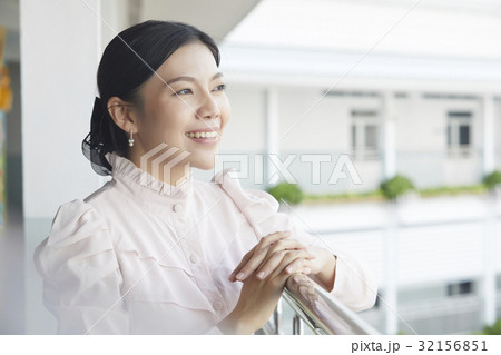 A portrait of a teacher smiling on the lobby and looking something. 32156851