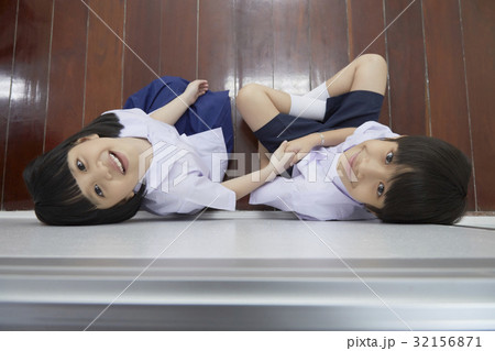 two students are sitting and looking at something on high two students are sitting and looking at something on high 32156871