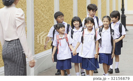 a group of pupils is walking towards the teacher 32156879