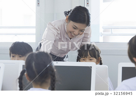 Teacher is teaching her students in the computer lesson Teacher is teaching her students in the computer lesson 32156945