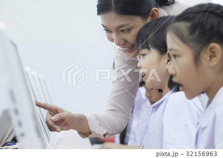 a teacher is pointing something for her students 32156963