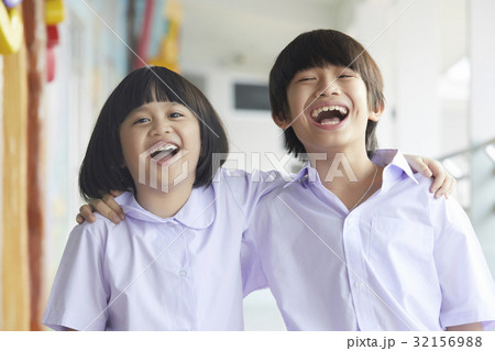 two children are putting arms over each other and laughing 32156988
