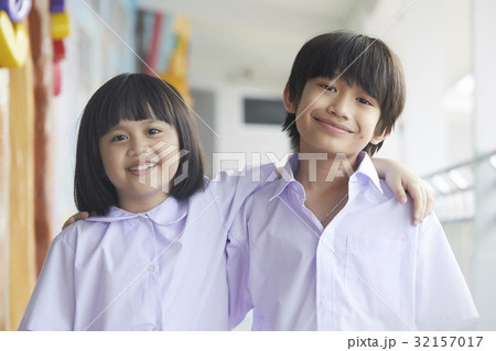 Two students are putting arms on each other's shoulder and smiling 32157017