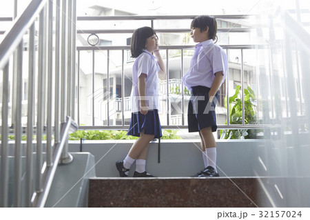 A schoolgirl is standing on the hallway and talking with her schoolboy 32157024