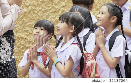 Thai pupils are smiling and greeting their teacher. 32157064