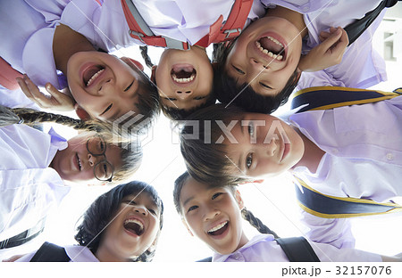 The primary pupils are gathering in a round, smiling and looking at camera. 32157076