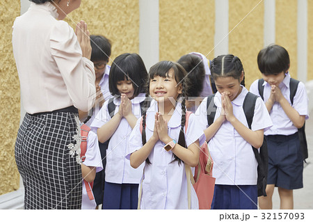 a photo of a teacher and her pupils standing and greeting each other. a photo of a teacher and her pupils standing and greeting each other. 32157093