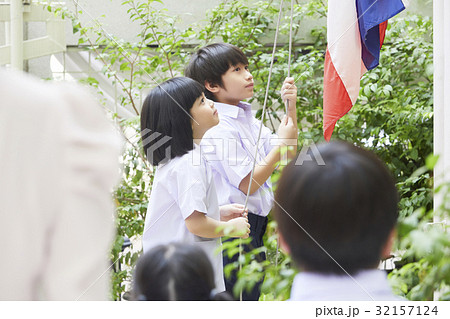 a picture of a couple of pupils standing in the schoolyard and slowly raising the flag a picture of a couple of pupils standing in the schoolyard and slowly raising the flag 32157124