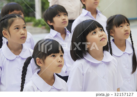 a group of children in uniform is concentrating on something. a group of children in uniform is concentrating on something. 32157127