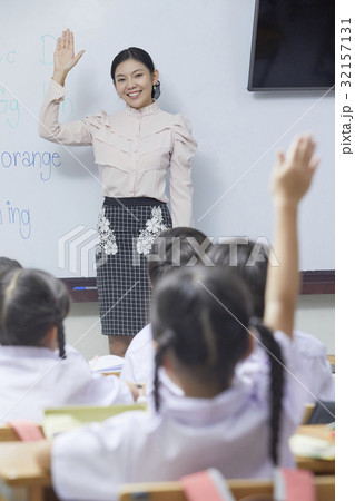a picture of happy teacher teaching and raising hand in the class 32157131