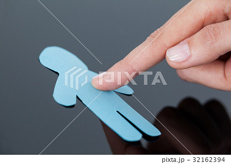 Fingers of a woman touching human paper cut out on a glass Fingers of a woman touching human paper cut out on a glass 32162394