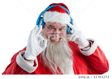 Santa claus showing hand okay sign while listening to music on headphones 32163253