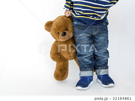 Young boy standing and holding teddy Young boy standing and holding teddy 32164861