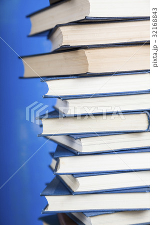 Stack of books on a blue background. 32168843