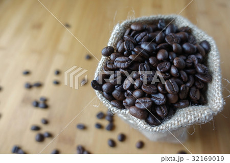 Coffee beans in a sack on wooden table 32169019