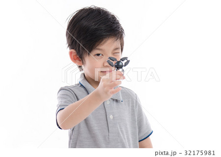 Asian chld  holding two fidget spinners 32175981