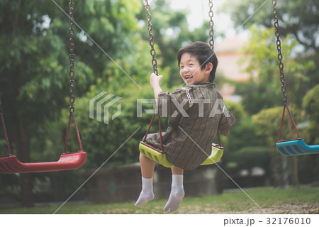 Asian child in kimono playing on swing i 32176010