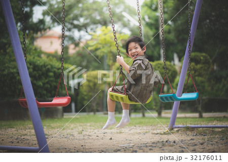 Asian child in kimono playing on swing i Asian child in kimono playing on swing i 32176011