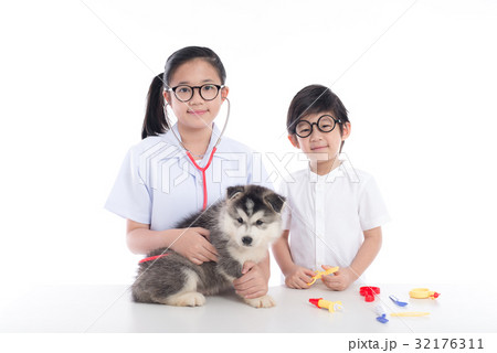 Asian children playing veterinarian with puppy 32176311