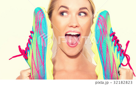 Happy young woman holding shoes 32182823