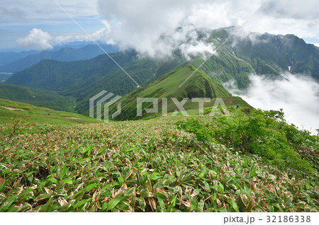 雲わく谷川主稜線と登山者 32186338