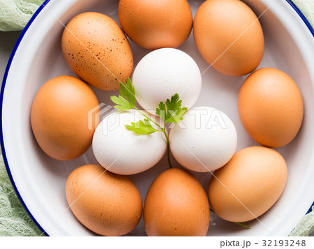 White and brown hen eggs in bowl 32193248