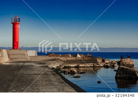 Red lighthouse on breakwater dam 32194346