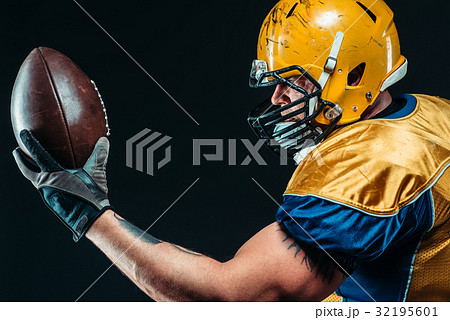 American football player with laced ball in hands 32195601