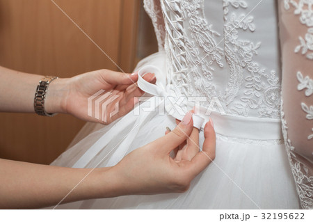 Mom helps daughter to wear wedding dress 32195622