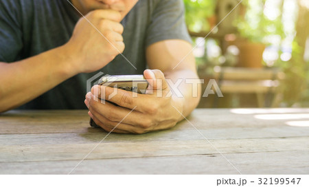 Man using a smartphone in a garden. Man using a smartphone in a garden. 32199547