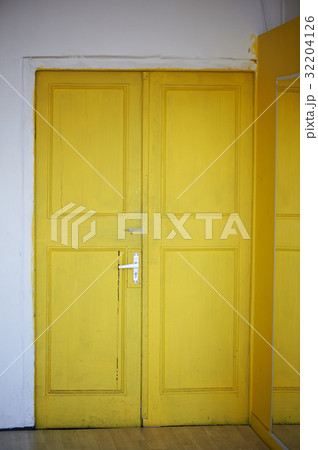 The yellow door in the doorway, white walls 32204126