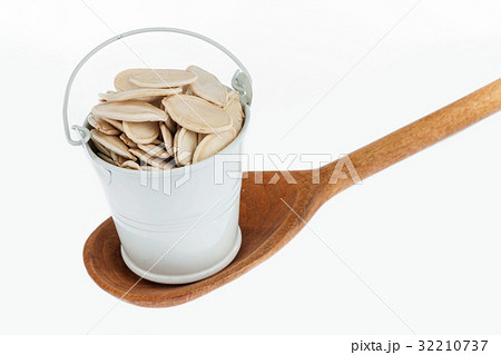 Full bucket of pumpkin seeds stands in spoon. 32210737