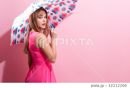 Happy young woman holding an umbrella  32212200