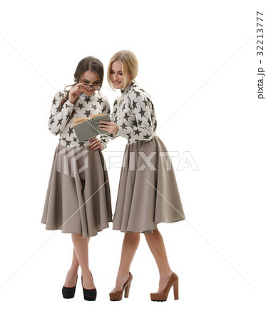 Smart young girls posing in studio with a book 32213777