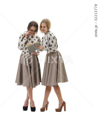 Smart young girls posing in studio with a book 32213778