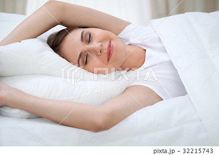 Woman stretching in bed after wake up, entering a Woman stretching in bed after wake up, entering a 32215743