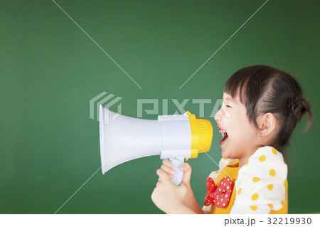 happy kid shouts something into the megaphone 32219930