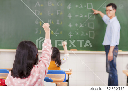 Elementary school students raising hands Elementary school students raising hands 32220535