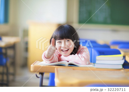 happy kid thumb up with book in class 32220711