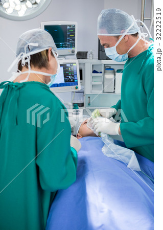 Surgeons placing oxygen mask on patient mouth 32222519