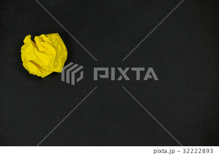 Yellow crumpled paper ball on a black background 32222893
