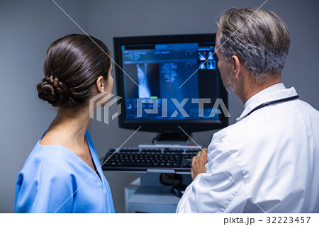 Doctor and nurse examining x-ray on computer Doctor and nurse examining x-ray on computer 32223457