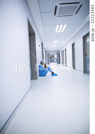 Sad surgeon sitting on a floor 32223483