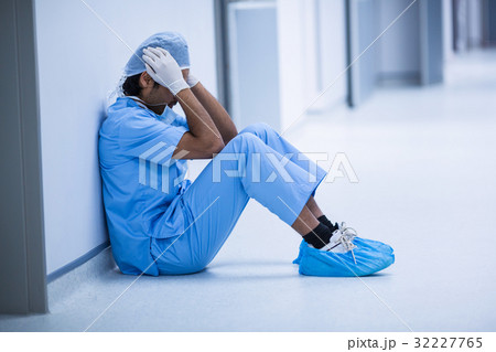 Sad surgeon sitting on a floor 32227765