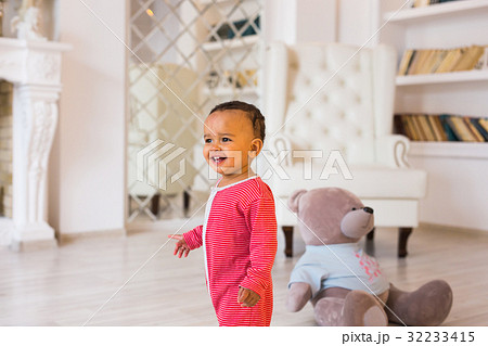 Happy baby boy playing with his teddy bear 32233415