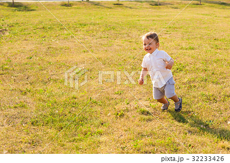 Happy baby boy running on summer field Happy baby boy running on summer field 32233426