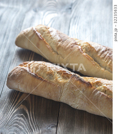 Two baguettes on the wooden background Two baguettes on the wooden background 32235633