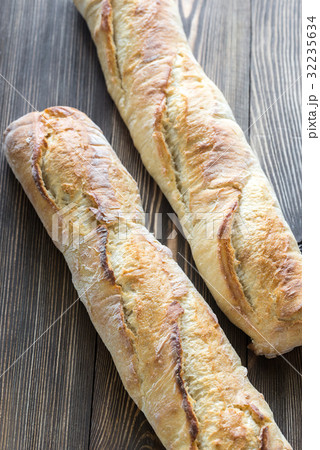 Two baguettes on the wooden background Two baguettes on the wooden background 32235634
