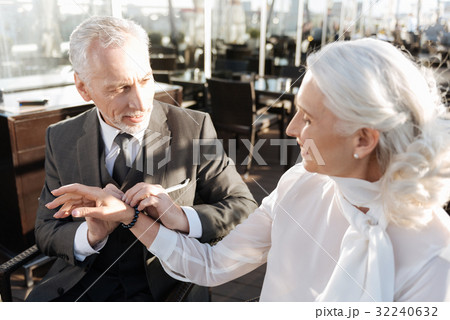 Serious bearded male person holding bracelet in 32240632